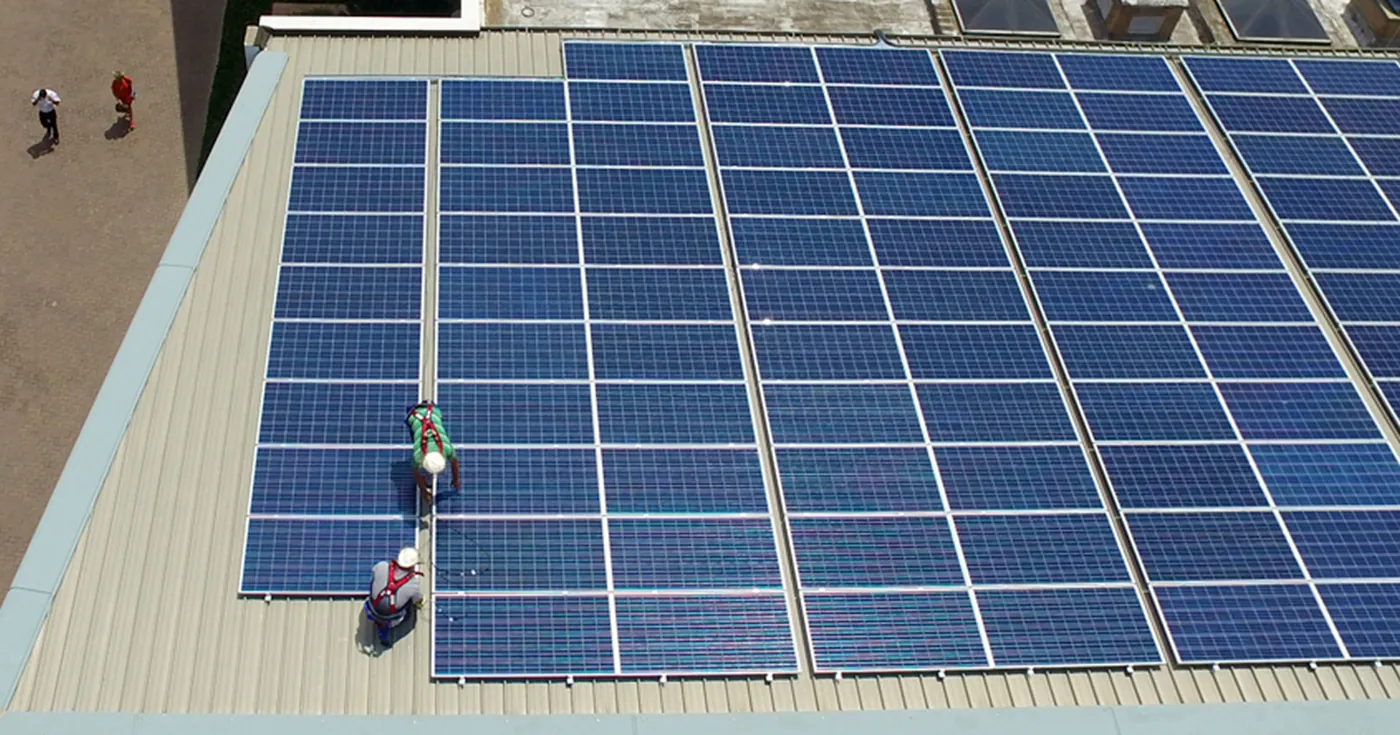 Instaladores montando paneles sobre una cubierta metálica